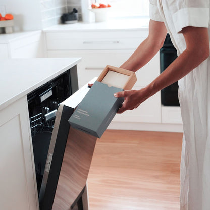 Concentrated lemon myrtle dishwasher sheet being added to dispenser for spotless, streak-free results. Non-toxic cleaning.